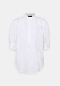 Blouse blanche à manches longues avec col montant, patte de boutonnage cachée et manches bouffantes rassemblées à de larges poignets.