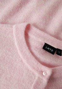 Hellrosa Pullover aus weichem Material, mit Rundhalsausschnitt, kleiner Knopfschließe und „LMTD“-Markenlabel.