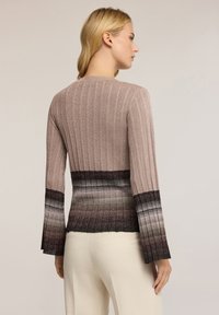 Maglione a maniche lunghe lavorato a maglia in diverse tonalità di rosa e nero. Presenta righe verticali e maniche svasate con transizioni di colore a gradiente.