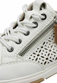 Sneaker bianco in pelle con fori decorativi, occhielli in metallo, lacci bianchi e una cerniera laterale con un accento in pelle marrone.