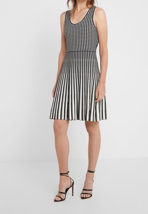 Sukienka bez rękawów w biało-czarne paski, z dopasowanym gorsetem i rozkloszowanym dołem, z teksturowanym wzorem i gładkim wykończeniem materiału.