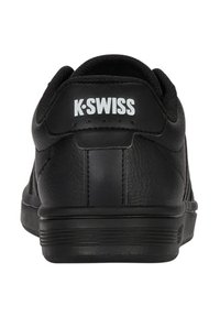 Tenis cu piele neagră, cu suprafață texturată, logo alb "K-Swiss" și talpă din cauciuc durabilă; dispune de guler căptușit și un design simplu.