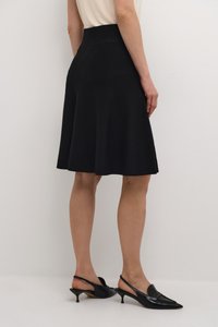 Jupe noire en A avec un tissu lisse et extensible ; longueur genou, dotée d'une taille ajustée et d'un léger évasement à l'ourlet.