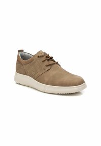 Zapatos deportivos marrones con textura y diseño de cordones, suela clara contrastante, detalles perforados en los laterales y forro interior a rayas.