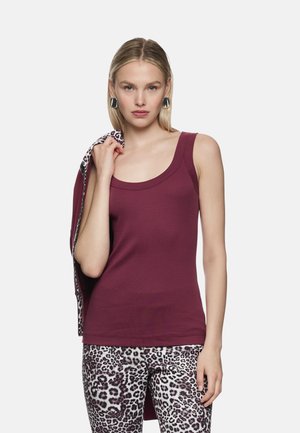 Bordeauxrotes, figurbetontes Tanktop mit weitem Ausschnitt, kombiniert mit Leggings mit Leopardenmuster. Das Material wirkt glatt und dehnbar.