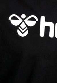 Zwarte t-shirt met een witte bijafbeelding boven het woord "hive," met een gladde textuur en eenvoudige, gedurfde ontwerpelementen.