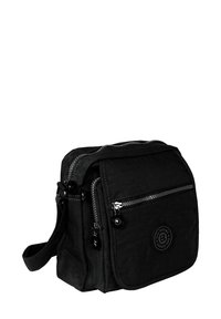 Schwarze Stoff-Umhängetasche mit zwei Reißverschlussfächern, verstellbarem Schultergurt und einem runden Logopatch auf der Vorderseite. Strukturiert Oberfläche und robustes Design.