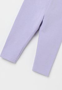 Lyserøde leggings lavet af blødt, strækbart stof, med et tætsiddende design, smal talje og kantede manchetter, glat tekstur.