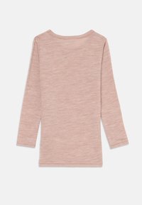 Langermet skjorte i lys rosa ribbet stoff med rund hals. Teksturen er lett elastisk, med rette sømmer og lange ermer.