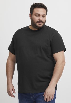 Camiseta negra de algodón con cuello redondo y mangas cortas, que presenta un corte relajado y una textura suave y uniforme. Diseño simple sin patrones.