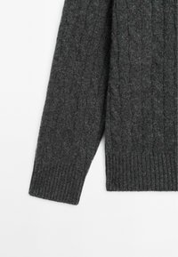 Manica di un maglione lavorato a maglia grigio scuro con polsino a coste e design a trecce testurizzato, realizzato in un morbido materiale misto lana.