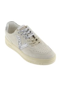 Beige suède sneaker met geperforeerde neus, dubbelgekleurde veters, zilveren glinsterend V-logo aan de zijkant en een crèmekleurige rubberen zool.