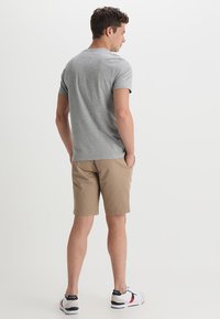 Gray short-sleeve t-shirt, beige shorts, black and white sneakers with red accents. Plain design, lightweight fabric, casual fit.