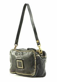 Borsa a tracolla in pelle nera con finitura testurizzata, borchie dorate lungo i bordi e una tracolla corta. Presenta una chiusura con zip e una patch quadrata con logo.