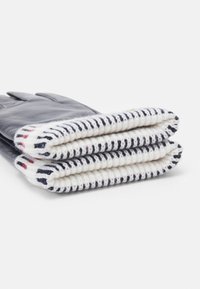 Marineblå læderhandsker med en hvid strikket manchet, der har marineblå og røde striber. Manchetten er blød; handskerne har en glat, elegant finish.