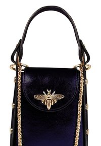 Kleine zwarte leren handtas met een glanzende afwerking, voorzien van een gouden bijsluiting, kettinghengsel en decoratieve studs langs de zijkant.