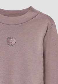 Jasnoliliowa bluza z ribbowanym dekoltem. Posiada błyszczące różowe logo w kształcie serca z pękniętym wzorem, umieszczone na gładkiej fakturze materiału.