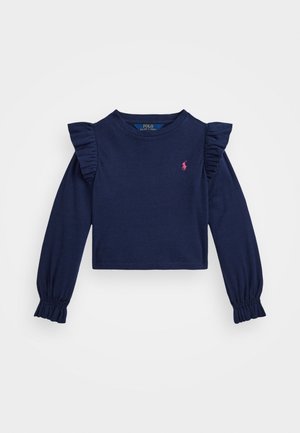 Camisa azul marino de manga larga con detalles de volantes en los hombros, puños fruncidos y un pequeño logo rosa en el pecho. Hecha de material de algodón suave.