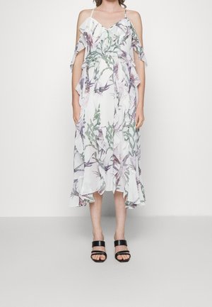 Abito midi floreale con maniche arricciate, caratterizzato da uno sfondo bianco e stampe botaniche verdi e viola. Abbinate a sandali neri con strappi.