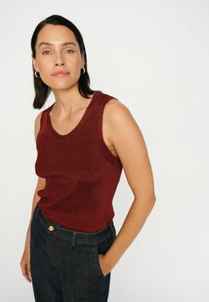 Burgundy ærmeløs ribbet top med en rundet halsudskæring, parret med mørkeblå denim jeans. Sættet har en afslappet pasform.