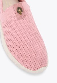 Różowy pleciony but wsuwany z teksturowaną cholewką, soft tkaniną oraz ozdobnym złotym emblematem z przodu; posiada gumową podeszwę.