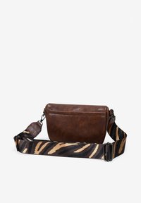Bolso cruzado de cuero marrón con una superficie texturizada y una correa ajustable a rayas en negro y beige que presenta un patrón de tigre.