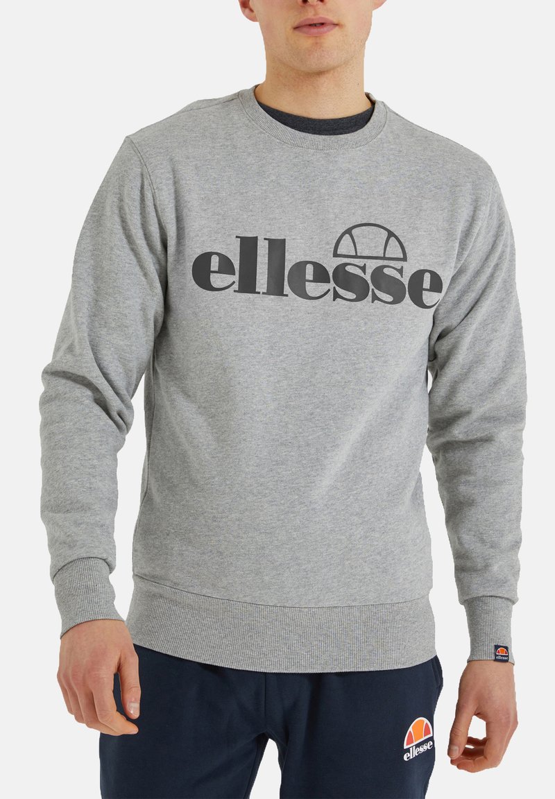 Grauer Pullover aus Baumwollmischung, mit großem schwarzen "ellesse"-Logo. Rippbündchen und -saum sowie runder Ausschnitt.