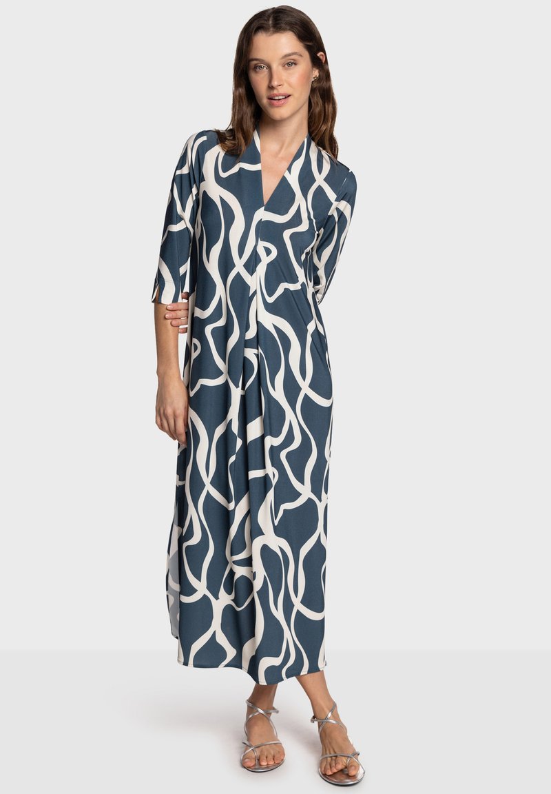 Abito lungo blu scuro con fantasie astratte bianche, caratterizzato da scollo a V e maniche a tre quarti. Realizzato in tessuto liscio.