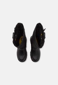 Bottes d'hiver noires avec un extérieur en cuir lisse, doublure douce, hauteur cheville et semelle robuste pour une bonne adhérence, avec une bande logo sur la tige.