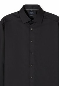 Zwart knoopshirt met een moderne pasvorm, voorzien van een klassieke kraag, zes knopen aan de voorkant en een gladde, gestructureerde stof. Label zichtbaar in de kraag.