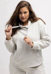Felpa grigia con cappuccio e lacci, caratterizzata da un'etichetta stampata che recita "Ama il tuo stile". Realizzata in un morbido tessuto testurizzato con una vestibilità rilassata.