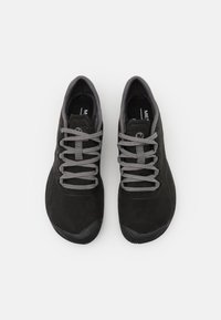 Scarpe sportive in suède nero con lacci grigi e suole in gomma. Presentano una punta arrotondata e un tallone testurizzato per una migliore presa. Design minimalista.