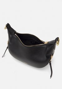 Sac à main en cuir noir avec une forme courbée, fermeture éclair dorée et accents. Présente une texture lisse et une seule bandoulière détachable.