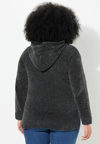 Grijze gebreide hoodie met een getextureerde afwerking, voorzien van een capuchon en een ribbelzoom. De achterkant laat een relaxte pasvorm en lange mouwen zien.