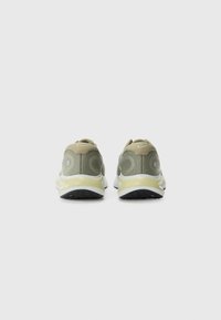 Green mesh running shoes with a reinforced heel, light yellow accents, and black rubber soles, featuring a rounded back design.