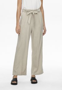 Pantalons larges en lin beige avec une taille cintrée et un détail de ceinture nouée. Comprend deux poches latérales et une coupe décontractée.