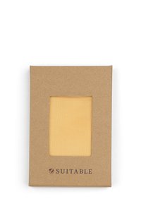 Bruine kartonnen verpakking met een venster dat gestructureerde gele stof toont. Het logo "SUITABLE" is in donkerbruin aan de onderkant gedrukt.
