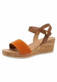 Sandal med kilehæl i kork. Har en brunt læder ankelrem og et orange suedebånd ved tæerne. Glat fodseng med en struktureret sål.