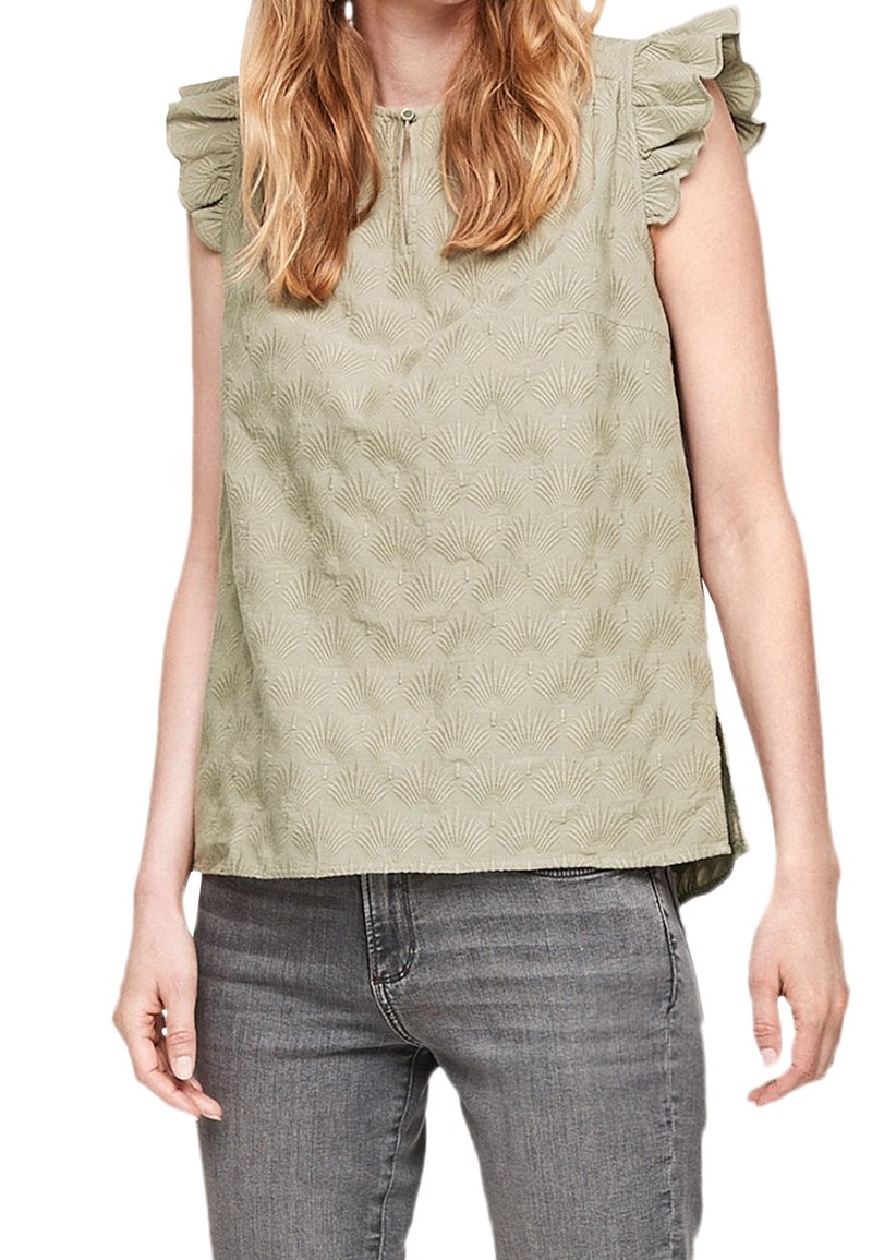 Haut sans manches vert clair avec épaules volantes, présentant un motif texturé de feuilles de palmier et une fermeture éclair en forme de trou de serrure à l'avant.