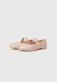 Ballerines roses texturées avec un bout rond, dotées d'une sangle avec une boucle et d'une semelle plate. Le matériau ribblé ajoute un intérêt visuel.