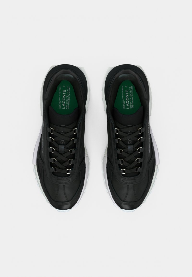 Sneakers atletiche nere con tomaia in pelle strutturata, dettagli riflettenti e lacci rotondi. Caratterizzate da una suola ammortizzata e etichetta interna verde.