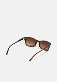Ochelari de soare tortoise brown cu lentile degrade, design unghiular și brațe subțiri. Accente aurii la balama pentru un detaliu suplimentar.