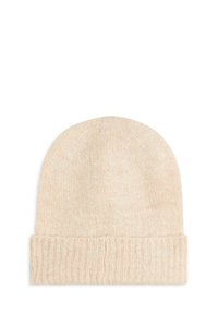Bonnet en tricot beige avec revers côtelé replié, texture douce, présenté sur un fond blanc uni.