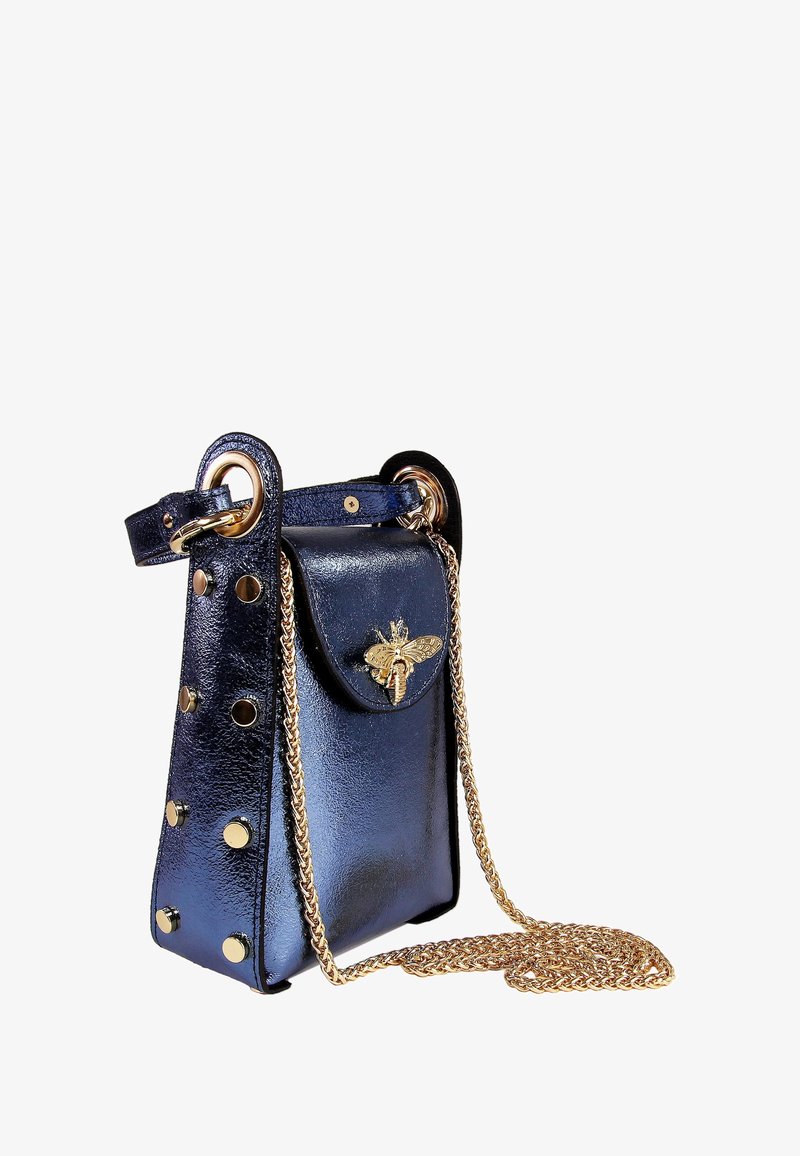 Marineblauwe handtas van nep leer met gouden beslag, voorzien van een bij-accent, ronde studs en een kettingriem. Compact en gestructureerd ontwerp.