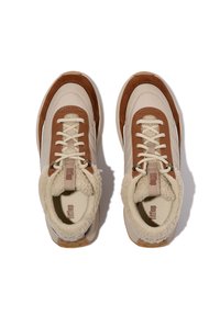 Baskets avec une tige beige, des accents en cuir marron et une doublure en fourrure crème. Dotées de lacets ronds et d'une semelle en caoutchouc texturée. Vue de dessus.