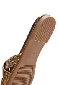 Sandal con tacco marrone caratterizzato da una suola testurizzata, cinturini decorati con borchie dorate e un bordo superiore metallico liscio. Taglia contrassegnata come 37.
