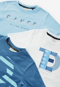 Tres camisetas en tonos azules y blancas. Cuentan con cuellos redondos, mangas cortas y gráficos llamativos con el texto "BAKER" y "TED BAKER".