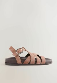 Sandal in suede marrone con più cinturini incrociati, punta rotonda e fibbia argentata regolabile. Suola piatta e design minimalista.