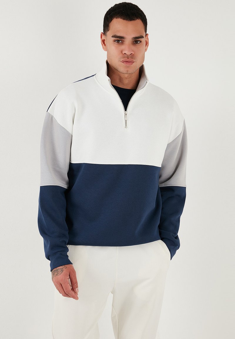 Kvartsdragkedja sweatshirt i vitt, grått och marinblått med färgblock, tillverkad av mjukt tyg, med långa ärmar och ribbade mudd.