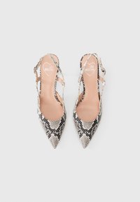 Spisse-skovler slingback-sko i svart og hvit slangeskrift med en beige innersåle, med en tynn ankelstropp og en lav hæl.